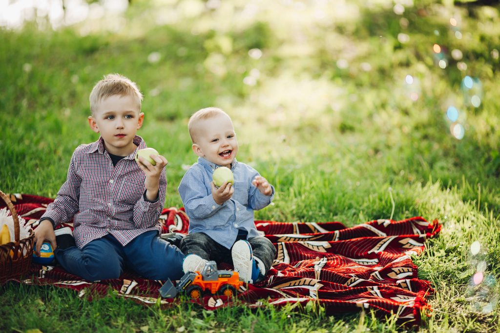 Two boys eating apples. Protect your kids from mosquitoes.